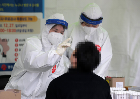 29일 오전 광주광역시 시청광장에 설치된 코로나19 임시 선별검사소에서 의료진이 한 시민의 코로나19 검체를 채취하고 있다. 연합뉴스